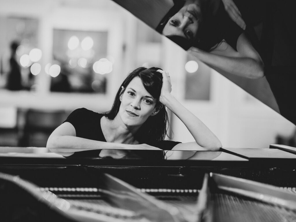 Portrait Verena Zeiner mit Klavierflügel in schwarz-weiß