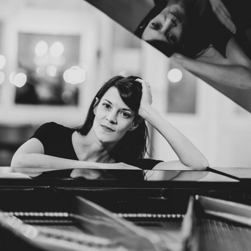 Portrait Verena Zeiner mit Klavierflügel in schwarz-weiß